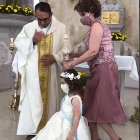 padre recebe high five de garotinha durante bencao