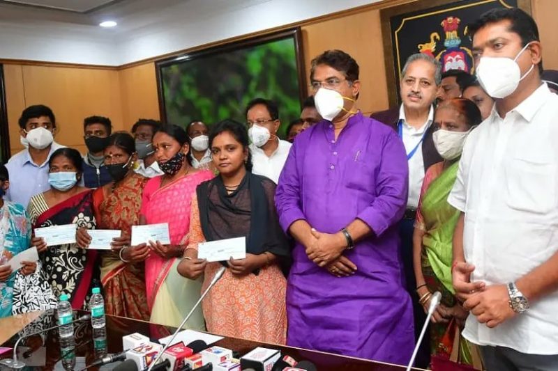 revenue minister ashok distributes 1 lakh rupees to families who lost a member due to Covid 19